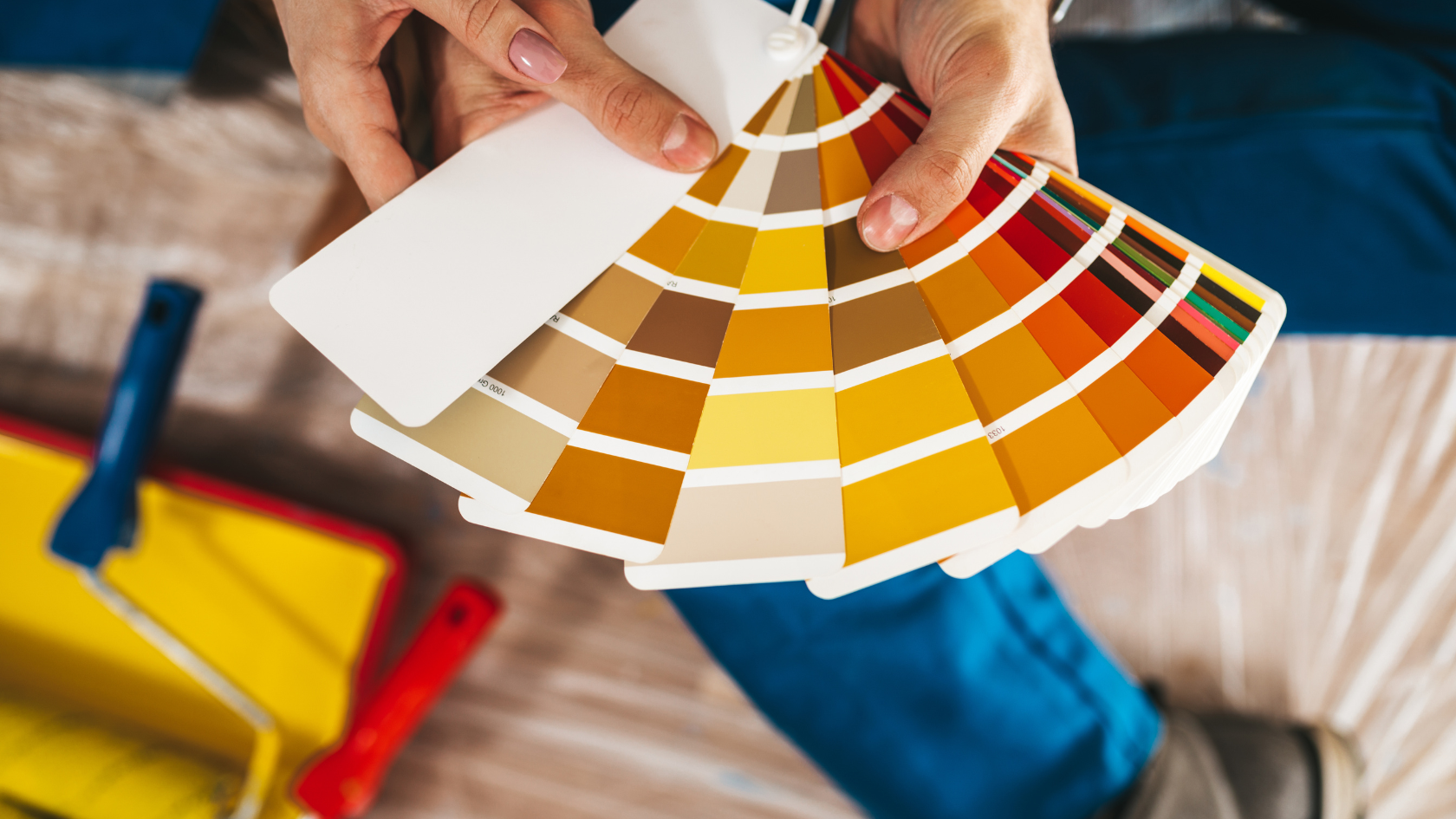 A person holding a pan of paint samples